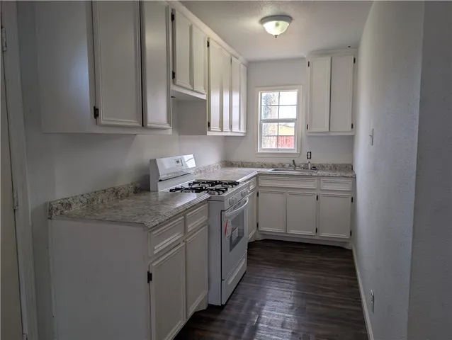 a kitchen with stainless steel appliances granite countertop a sink stove and cabinets
