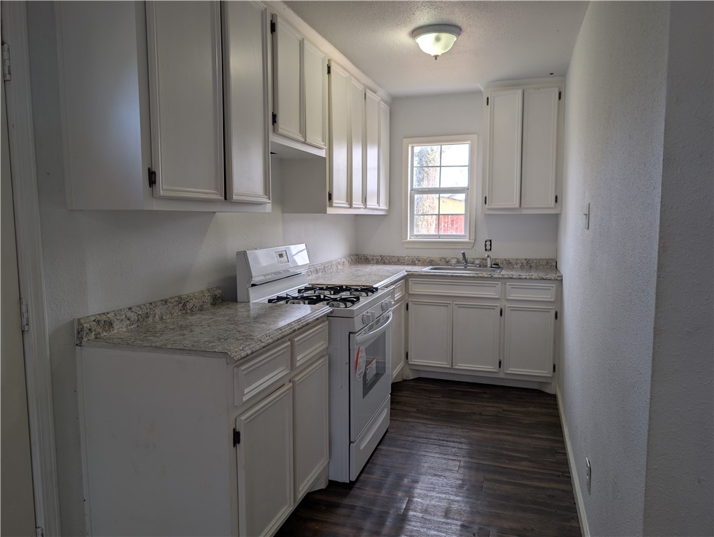 610 25th Street Corpus Christi, TX 78405 - Photo 4 of 11 a kitchen with stainless steel appliances granite countertop a sink stove and cabinets