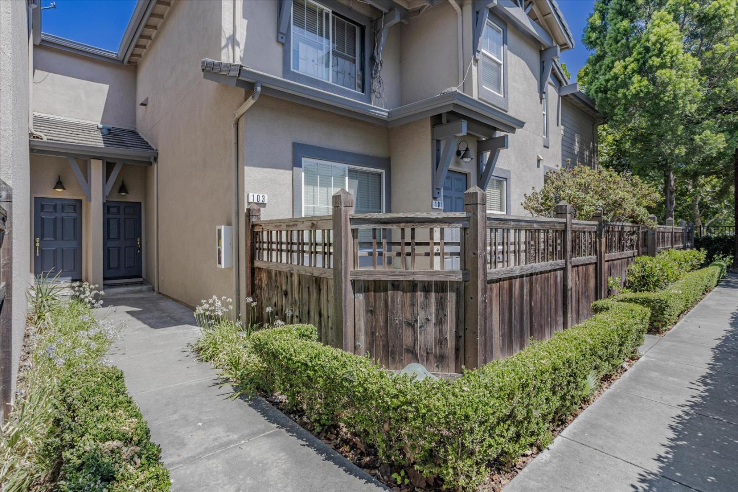 105 Serenity Place Milpitas, CA 95035 - Photo 4 of 36 a view of a brick house with a small yard plants and large trees