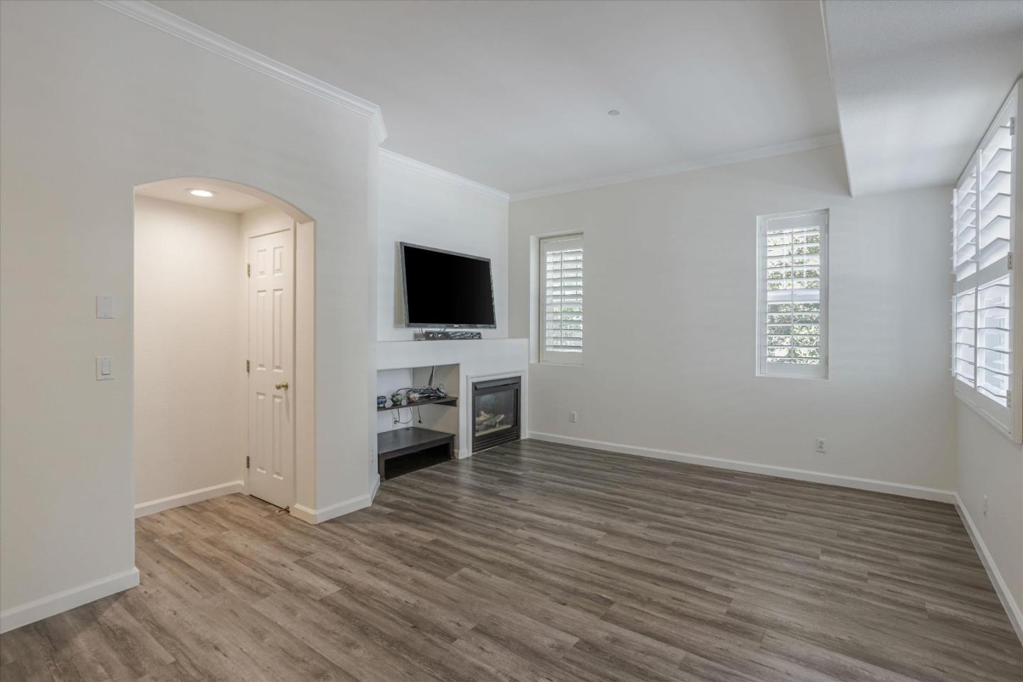 105 Serenity Place Milpitas, CA 95035 - Photo 8 of 36 a view of a livingroom with wooden floor a flat screen tv and windows