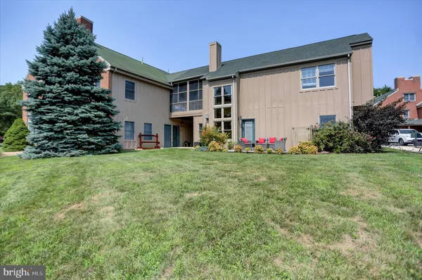a front view of a house with a yard and trees