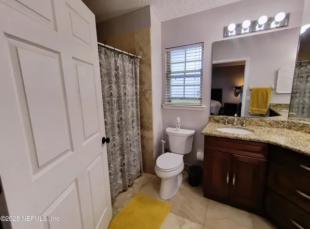 a bathroom with a sink toilet a mirror a vanity and shower