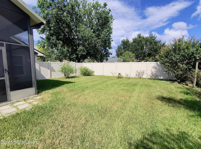 a view of yard with swimming pool and trees in the background
