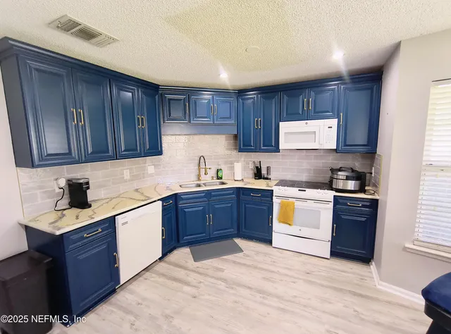 a kitchen with stainless steel appliances granite countertop a stove sink and cabinets
