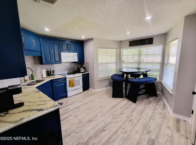 a kitchen with stainless steel appliances kitchen island granite countertop a sink dishwasher stove and refrigerator
