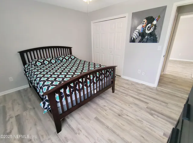 a bedroom with a bed and wooden floor