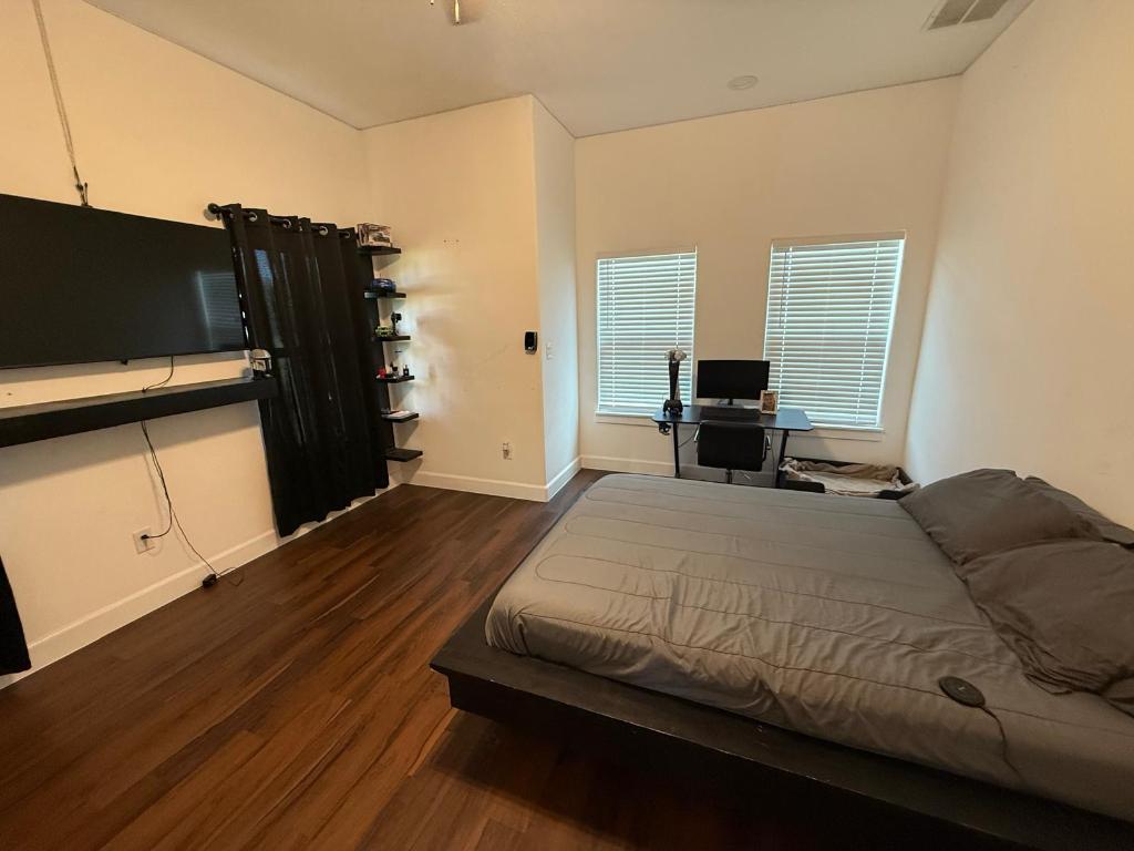 497 Brown Road McDade, TX 78650 - Photo 9 of 22 Bedroom with dark wood finished floors and baseboards