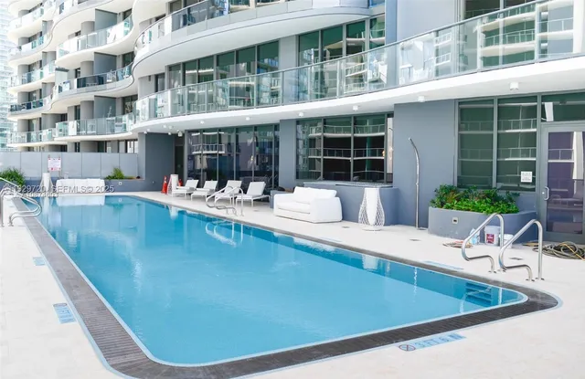a view of a house with swimming pool and sitting area