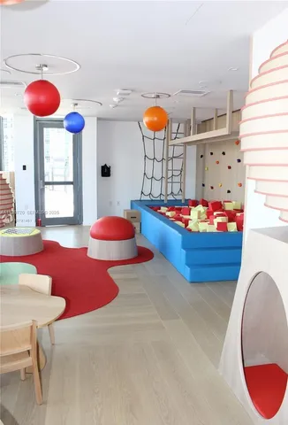 a living room with a rug toys and a wooden floor