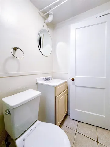 a bathroom with a sink a toilet mirror and vanity