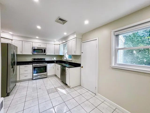 a kitchen with stainless steel appliances granite countertop a stove a sink and a refrigerator