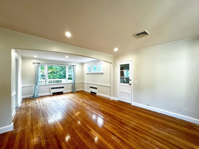 a view of a livingroom with wooden floor and furniture