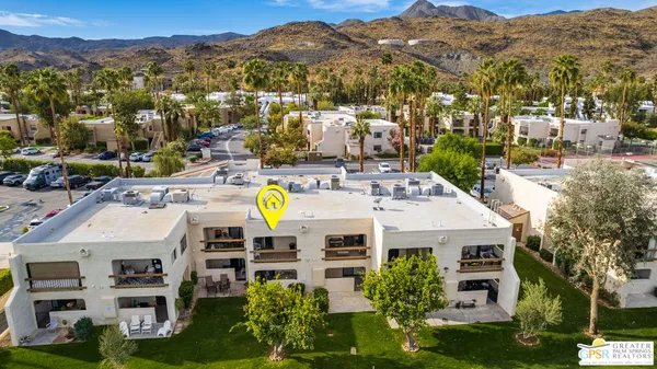 an aerial view of residential houses with outdoor space and parking