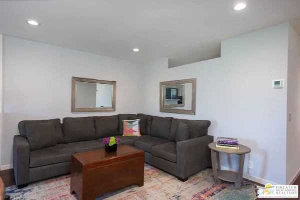 a living room with a couch and a potted plant