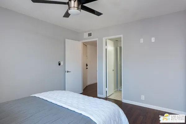 a bedroom with a bed and a painting on the wall
