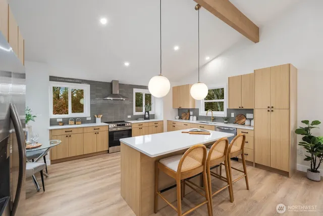 a kitchen with a dining table cabinets and stainless steel appliances
