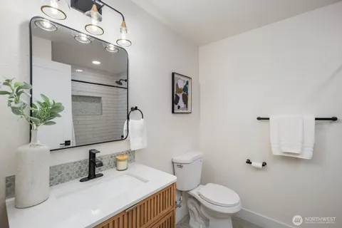 a bathroom with a sink a toilet and mirror