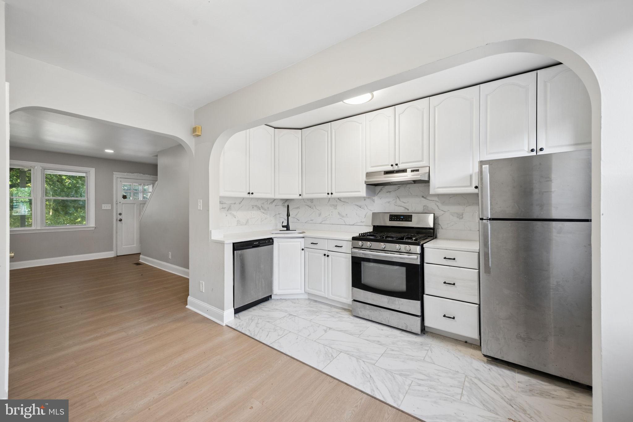 3548 Benzinger Road Baltimore, MD 21229 - Photo 10 of 40 a kitchen with a refrigerator stove and white cabinets