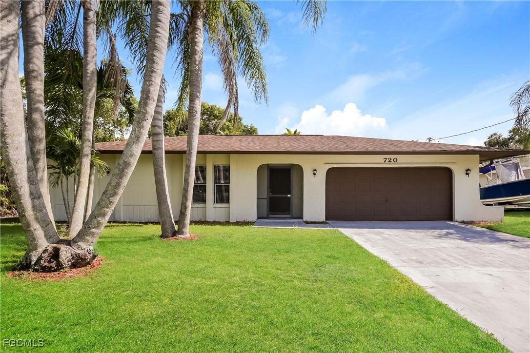 a view of a house with a yard and a palm tree