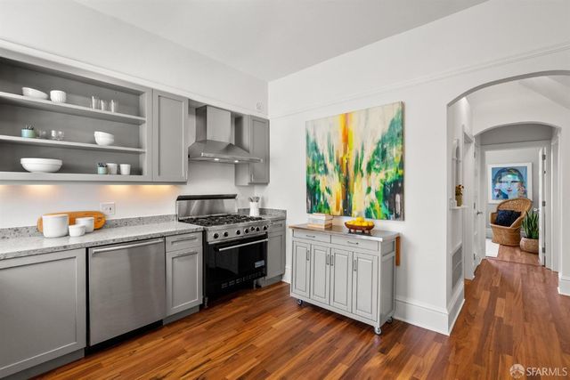 a view of a hallway with wooden floor and furniture