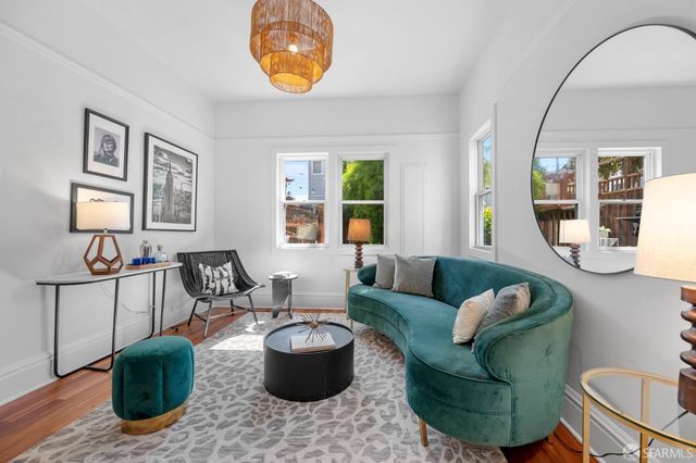 a living room with furniture a rug and wall painting