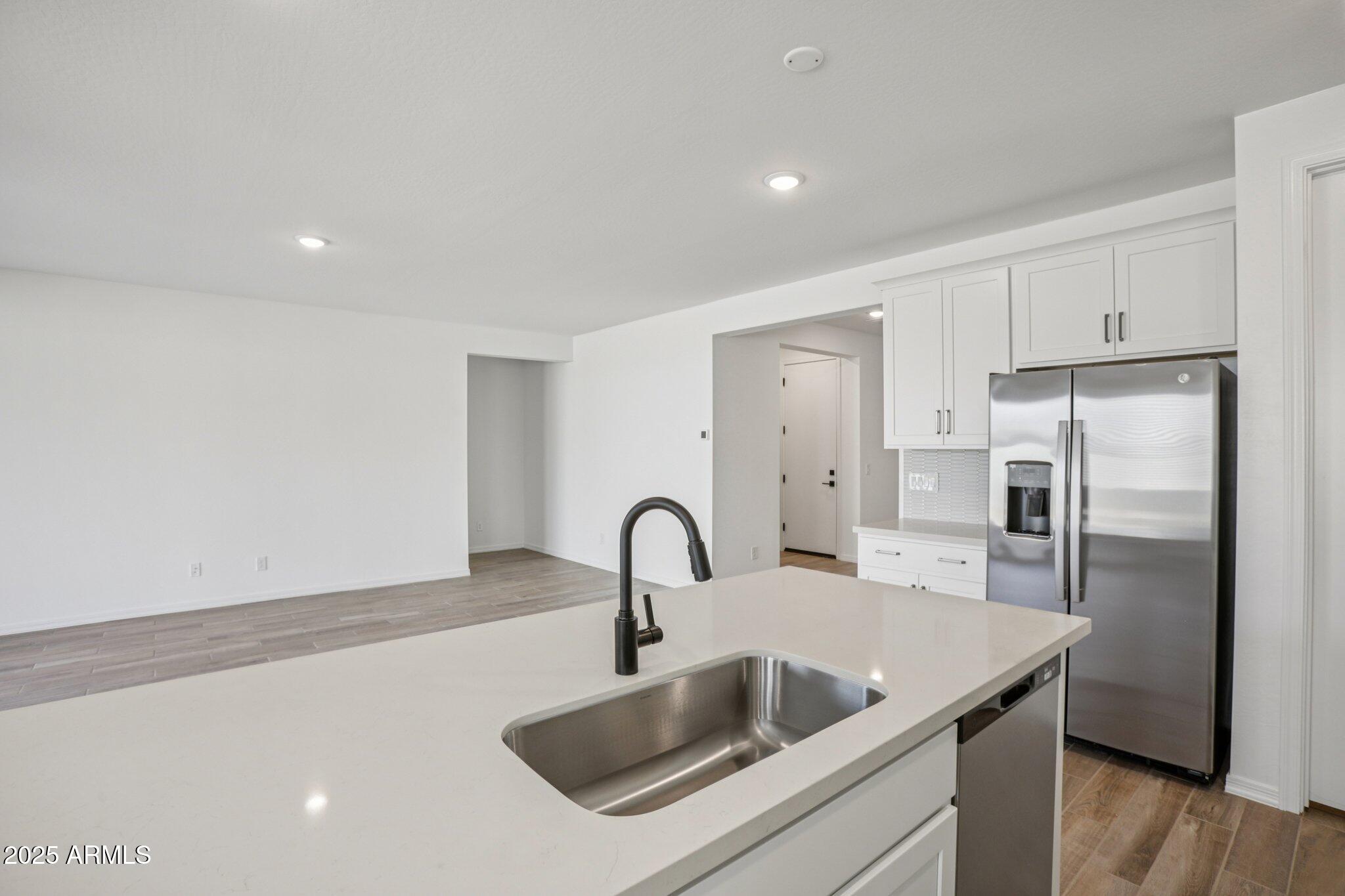 5528 West Hopi Trail Laveen, AZ 85339 - Photo 12 of 51 a kitchen with a sink a refrigerator and cabinets