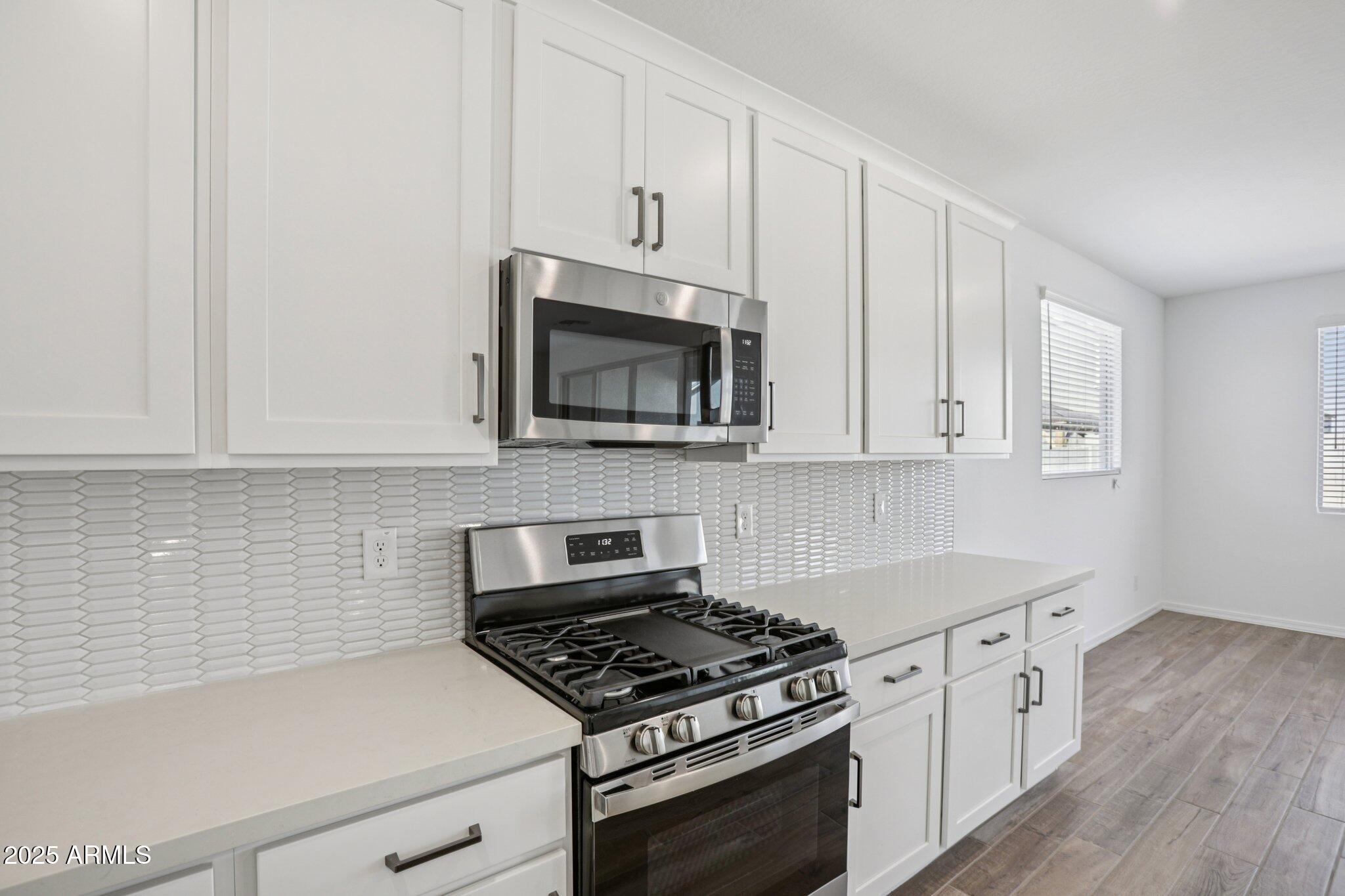 5528 West Hopi Trail Laveen, AZ 85339 - Photo 13 of 51 a kitchen with granite countertop white cabinets and stainless steel appliances