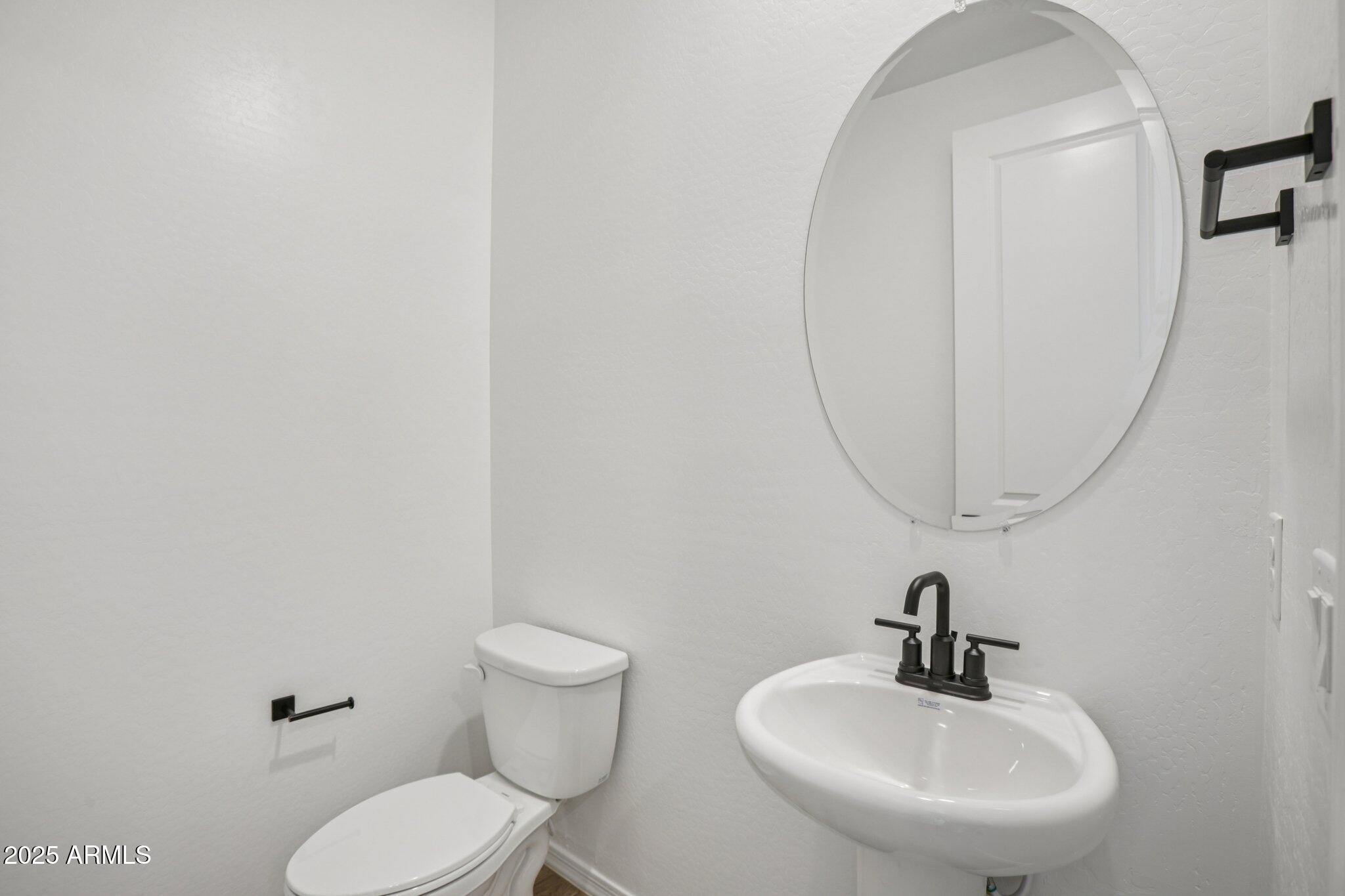 5528 West Hopi Trail Laveen, AZ 85339 - Photo 21 of 51 a bathroom with a toilet sink and mirror