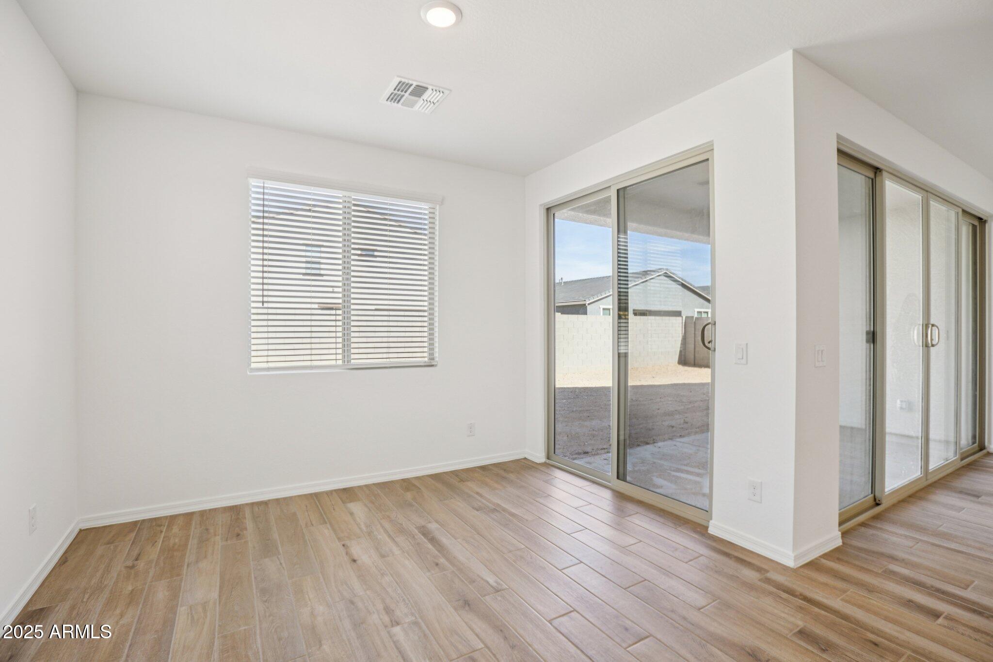 5528 West Hopi Trail Laveen, AZ 85339 - Photo 9 of 51 an empty room with wooden floor and windows