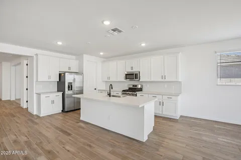 a kitchen with granite countertop white cabinets and stainless steel appliances