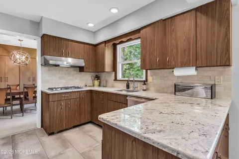 a kitchen with stainless steel appliances granite countertop wooden cabinets a sink and a stove