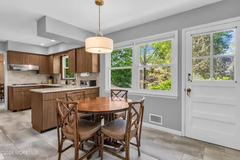 a dining room with furniture a chandelier and window