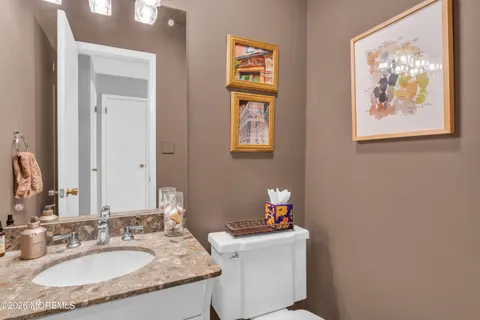 a bathroom with a granite countertop sink a toilet and a mirror