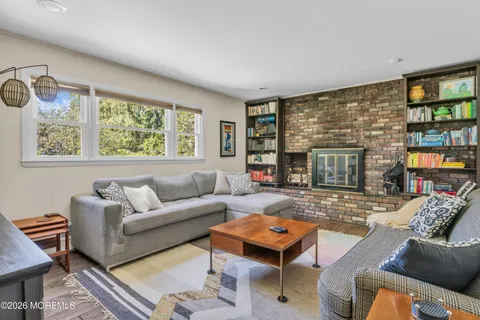 a living room with furniture a large window and a fireplace
