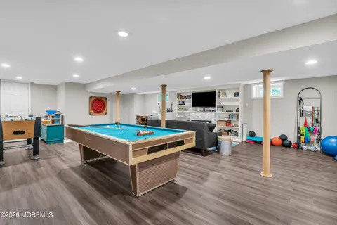 a living room with furniture pool table and a fireplace