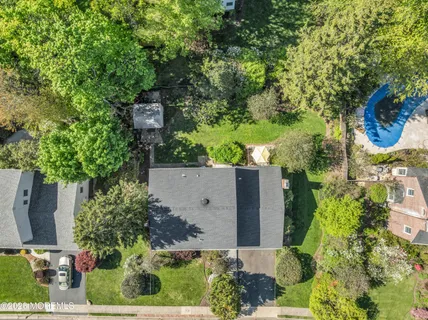 an aerial view of a house with a yard and tennis court
