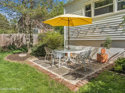 a view of a backyard with table and chairs under an umbrella