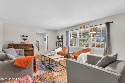 a living room with furniture and a floor to ceiling window