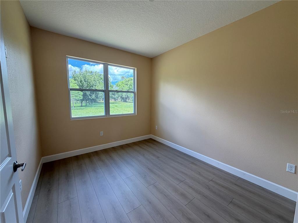 4661 Hickory Tree Road St. Cloud, FL 34772 - Photo 14 of 20 an empty room with wooden floor and windows