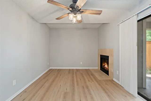 a view of empty room with a fireplace and wooden floor