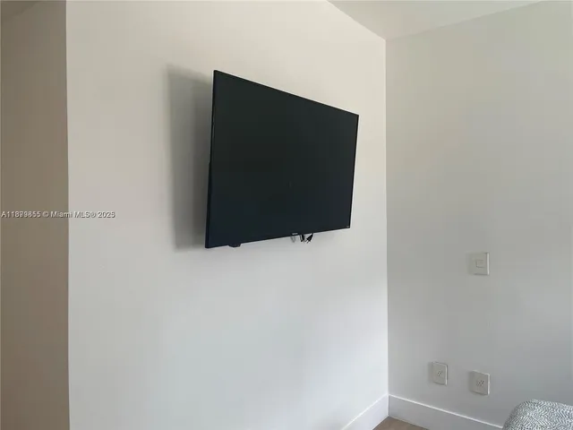 a living room with a flat screen tv and a wall painting