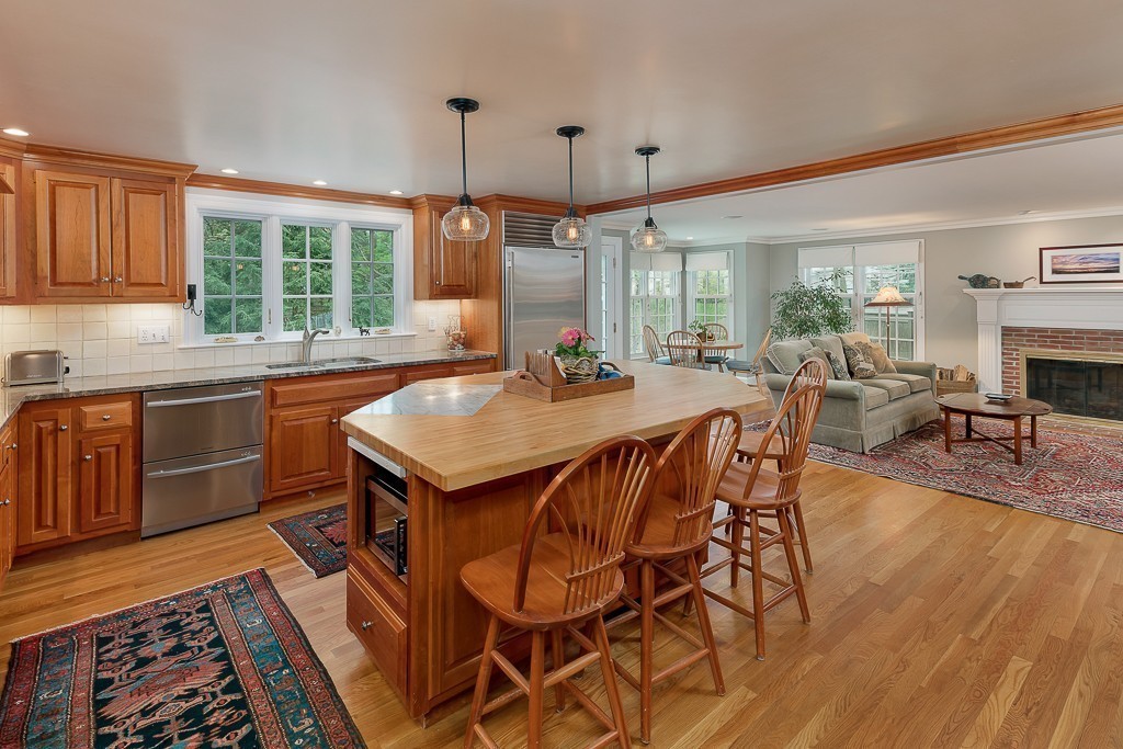 73 Audubon Road Wellesley, MA 02481 - Photo 6 of 24 a dining hall with stainless steel appliances granite countertop a stove a sink a dining table and chairs with wooden floor
