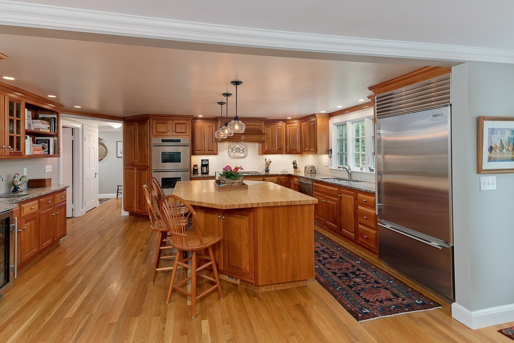 73 Audubon Road Wellesley, MA 02481 - Photo 7 of 24 a kitchen with stainless steel appliances a dining table chairs and wooden floor