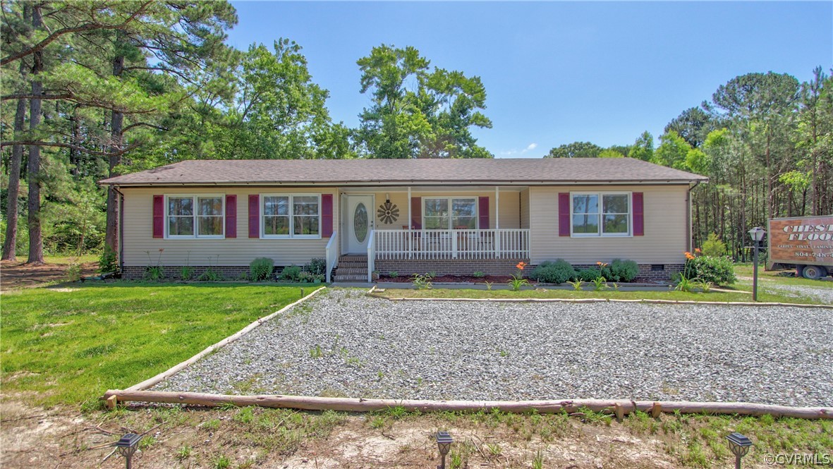 Ranch-style house featuring a porch and a front ya