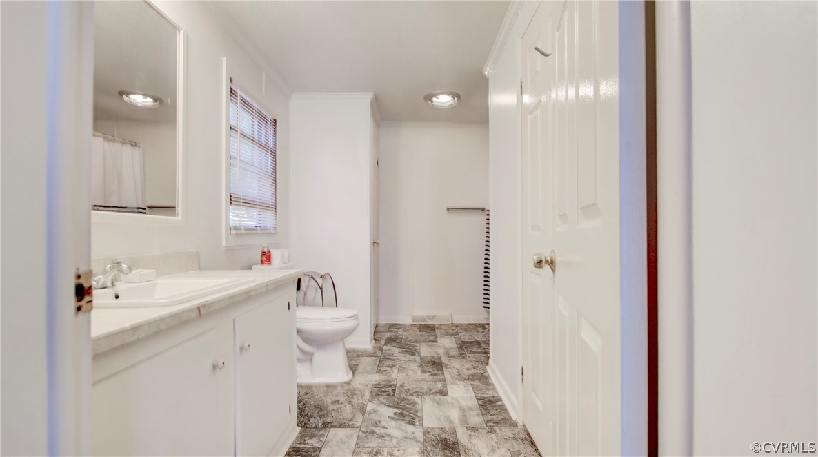 1694 Rolling Acres Road Emporia, VA 23847 - Photo 20 of 45 Bathroom with vanity, toilet, and tile patterned f