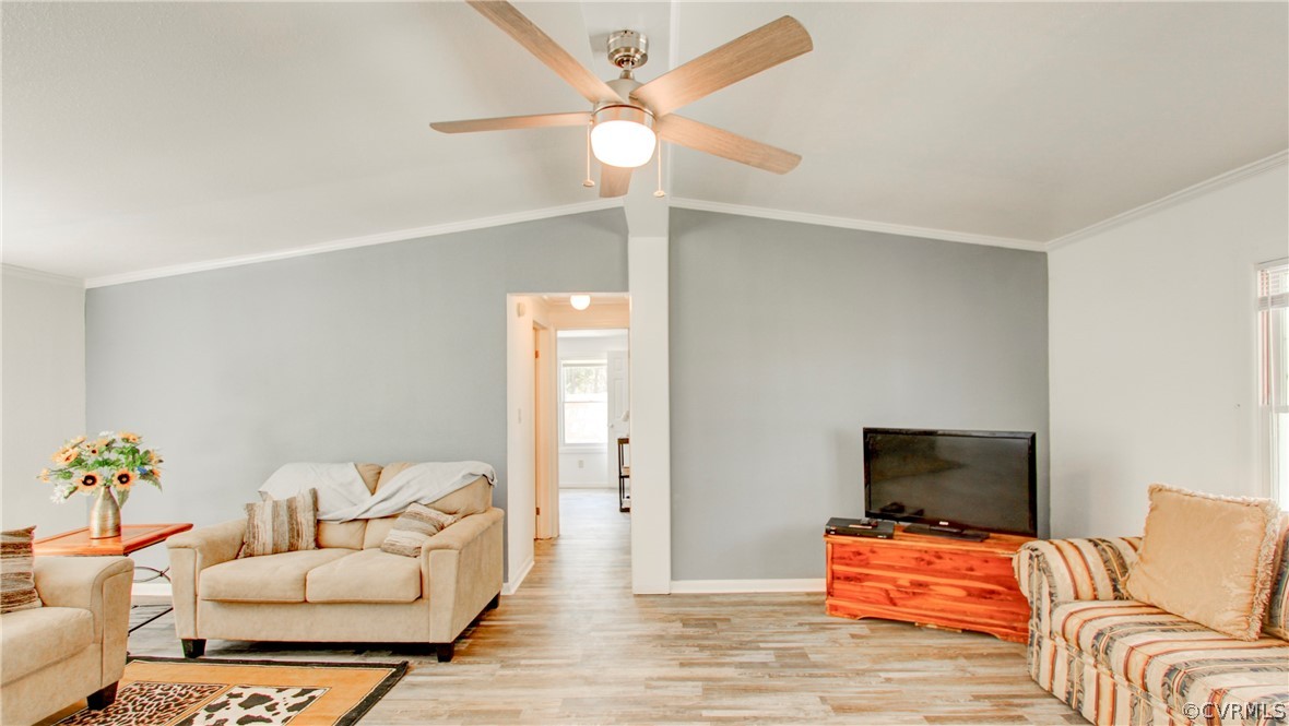 Living room with lofted ceiling, ceiling fan, ligh