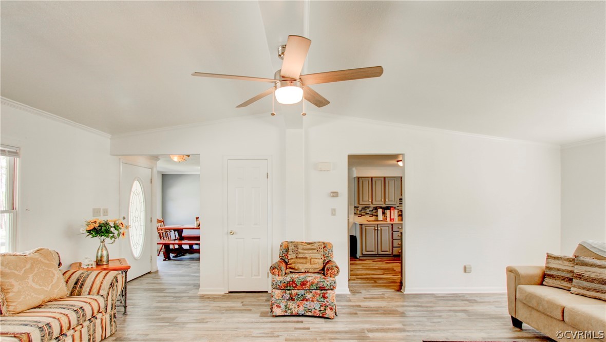 Living room with crown molding, light wood-type fl
