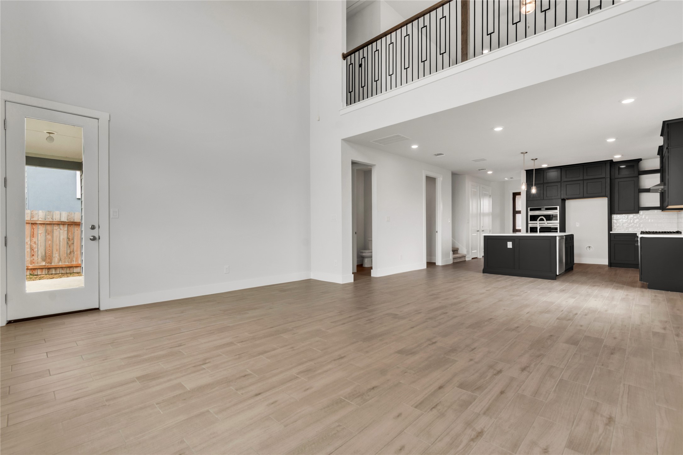 8500 Red Bottle Brush Road Lago Vista, TX 78645 - Photo 5 of 33 A grand, open-concept living space with lofty ceilings flows seamlessly into a modern, well-appointed kitchen.