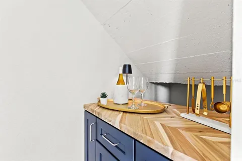 a kitchen with a sink a stove and wooden floor