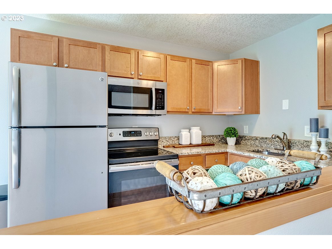 200 Southwest Florence Avenue, Unit C9 Gresham, OR 97080 - Photo 11 of 32 a kitchen with kitchen island a stove a sink and a refrigerator
